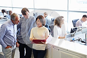 Casually dressed staff standing in a busy open plan office