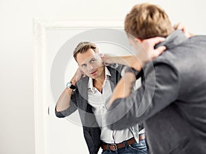 Casually dressed young handsome man in front of mirror