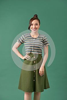 Casually dressed young woman over green background
