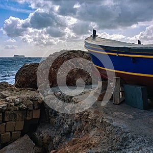 Cat in colourful boat on sunset in Marsaxlokk, Malta.