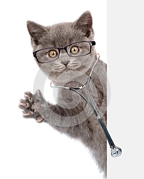 Cat with eyeglasses and with a stethoscope on his neck peeks out from behind a banner. isolated on white background photo