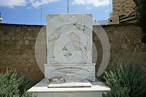 A cat lies in the shadows on a marble monument in Lardos, Rhodes Island, Greece