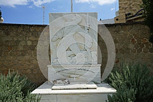 A cat lies in the shadows on a marble monument in Lardos, Rhodes Island, Greece