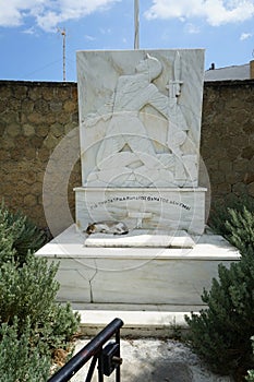 A cat lies in the shadows on a marble monument in Lardos, Rhodes Island, Greece