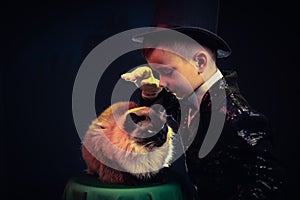 Cat and Magician kid illusionist boy in hat. mystery magical isolated black background