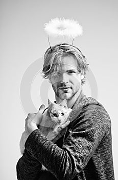 Cat and man with angel halo on head holding cat photo