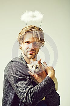 Cat and man with angel halo on head holding cat photo