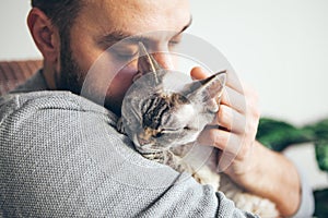 Cat and man, portrait of happy cat with close eyes and young beard man.