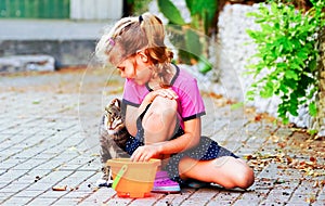 The cat rubs against the girl`s shoulder in the street