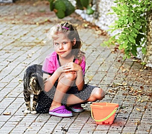 The cat rubs against the girl`s shoulder in the street