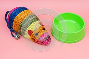 Cat toys with plastic bowl on color background.