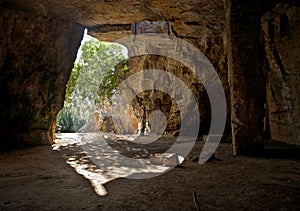 Catacomb entrance and inner part with tree and tied pieces of cl photo