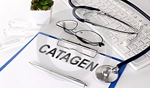 CATAGEN text on white paper on white background. stethoscope ,glasses and keyboard