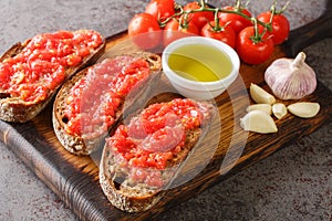 Catalan Pan con Tomate Spanish toasted bread rubbed with fresh garlic and ripe tomato, then drizzled with olive oil closeup on the photo