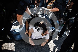 A catalan riot police detaining a protester