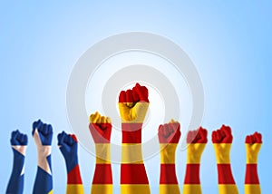 Catalan separatism concept with Senyera estelada Eastern Catalan lone star flag on people`s hand fists isolated on blue sky