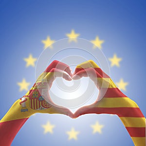 Catalonia Estelada flag  and Spain flag on Catalunya people`s heart-shape hands or Catalonia- Spanish unity supporter on EU