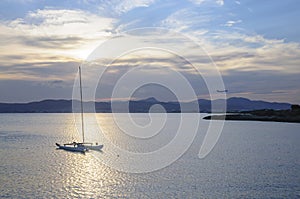 Catamaran moored at sunset and jetliner landing in Palma