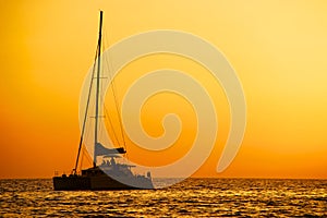 Catamaran sailing at sunset