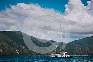 Catamaran ship in open sea near Fiskardo. Big clouds moving over the mountain shape of Ithaki island. Kefalonia Island photo