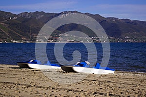 Catamarans boats on a sandy beach in the town of Pogradec against the backdrop of Lake Ohrid