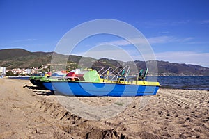 Catamarans boats on a sandy beach in the town of Pogradec against the backdrop of Lake Ohrid