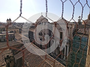 Catania, Italy: view of the old city obstructed by a chainlink fence photo