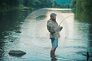 Catch fish. Holding brown trout. Portrait of cheerful man fishing. Angler.