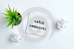 Catch unawares - english time idiom hand lettering on wooden blocks