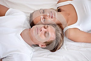 Catching 40 winks. Cropped view of a young couple lying in bed and looking up.