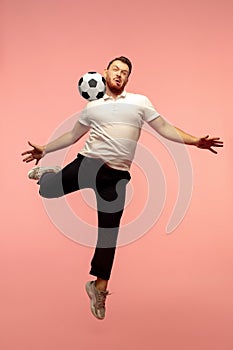 Full length portrait of young successfull high jumping man gesturing isolated on pink studio background