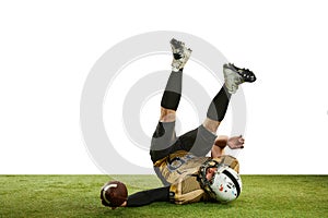 Catching ball and falling. Man, professional american football player in motion over white studio background with green