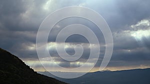 Catching the Light: Crepuscular Rays Amidst Mountain\'s Ever-Changing Clouds.