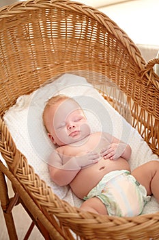 Catching a midday nap. Cute baby boy sleeping peacefully in his bassinet.