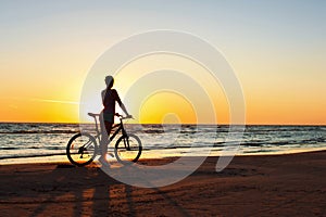 Catching a moment in time. Sporty woman cyclist at sunset background.