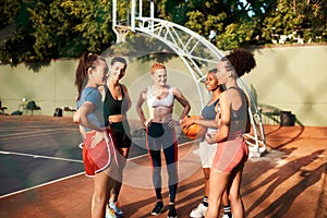 Catching up before the game. a diverse group of friends getting ready to play a game of basketball together during the