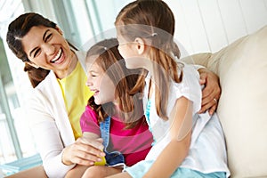 Catching up after a long week. A mother and her two daughters sharing a laugh together on the porch.