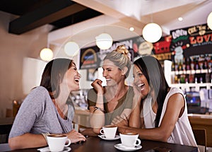 Catching up on the news. Shot of three friends having fun at a coffee shop together.