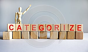 `Categorize` written on wood blocks. Business concept. Wooden model of human. Copy space. Beautiful white background photo