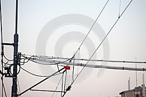 Catenary power overhead line of a railroad track, supplying electricity for trains, with a pylon pillar in the background