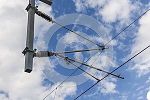 Catenary support in front of cloudy sky