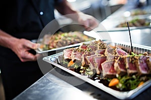 caterer organizing seared tuna steak dishes for an event