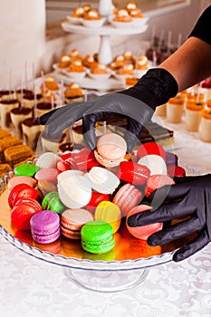 Catering bar for celebration. Colorful macaroons on a plate. Tasty desserts served on the table