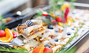 Catering buffet food outdoor. Cakes colorful fresh fruits berries oranges grapes and herb decorations