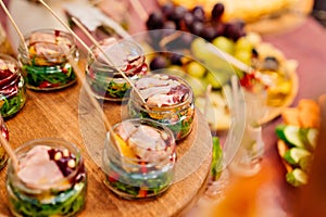 Catering. portioned serving of dishes. pate with salad in small glass jars.