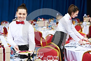 Catering restaurant waitress serving table with food