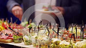 Catering service on banquet table with canape snacks in restaurant or hotel. Decorated food set on birthday, wedding