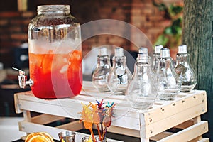 Catering service. Business, catering service. Drinks on summer party. Catering table with trendy glasses, big bottle of lemonade o