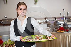 Catering service employee posing with tray for buffett