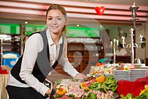 Catering service employee preparing a buffet